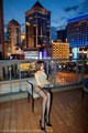 A woman sitting on a chair on a balcony at night.