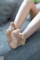 A close up of a woman's feet on a couch.