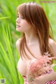 A woman in a red and white striped bikini holding a pink flower.