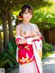 A woman in a red and white kimono posing for the camera.