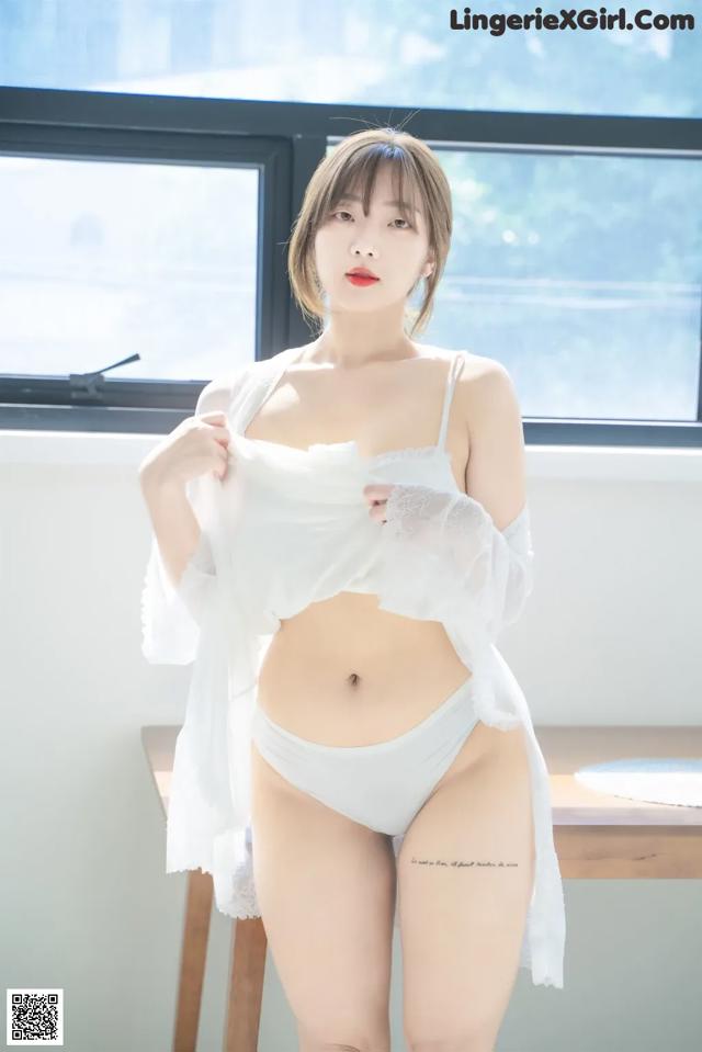 a woman in a white lingerie posing for the camera