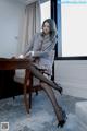 A woman sitting at a desk in a room.