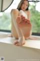 A woman sitting on a window sill with her feet up.