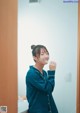 A woman brushing her teeth in front of a mirror.