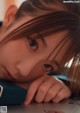 A young girl laying on the floor with her head resting on her hand.