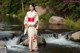 A woman in a kimono standing in a stream.