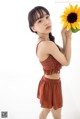 A woman holding a sunflower in her hand. 