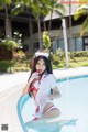 A woman in a nurse outfit sitting in a swimming pool.