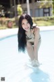 A woman in a bikini standing in a swimming pool.