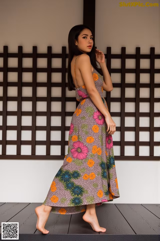 A woman in a long dress standing on a wooden floor.