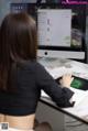 A woman sitting at a desk using a computer.