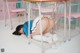 A woman in a school uniform is laying on a chair.