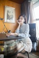 A woman sitting at a desk talking on a cell phone.