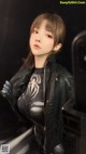 A woman in a black leather jacket posing for a picture.