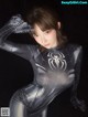 A woman in a black and silver spider suit posing for a picture.