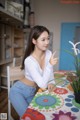 A woman sitting at a table pointing at something.