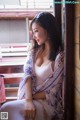 A woman sitting on a train looking out the window.