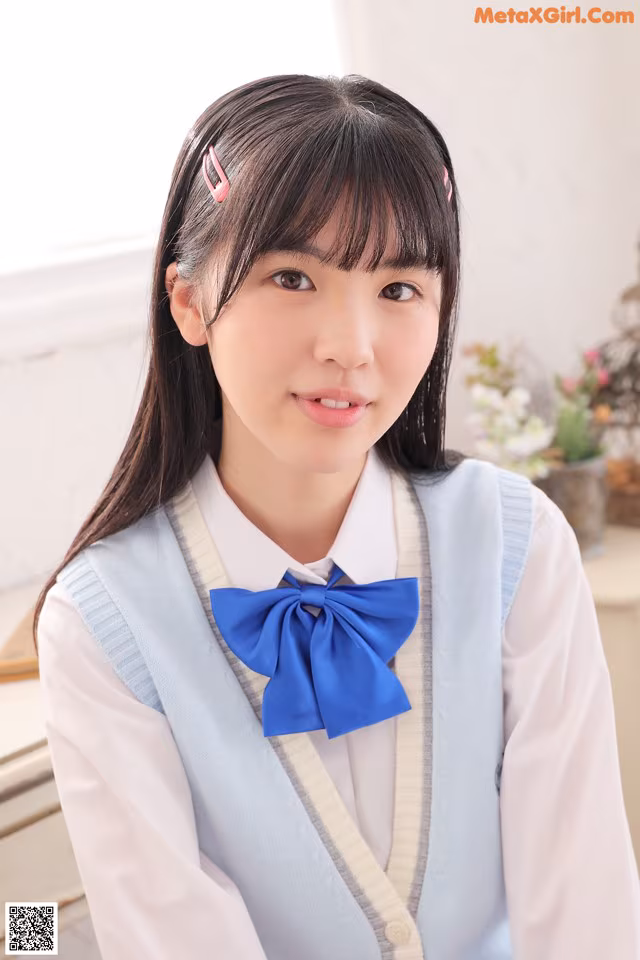 A young woman wearing a blue bow tie and a white shirt.