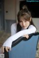 A woman sitting on top of a blue chair.