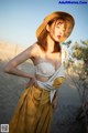 A woman in a straw hat is posing for a picture.